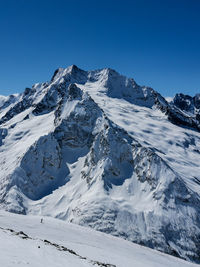 Scenic view of snowcapped mountains against clear blue sky