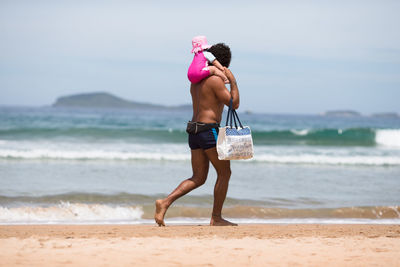 Full length of shirtless boy on beach