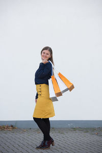 Full length portrait of woman standing against clear sky