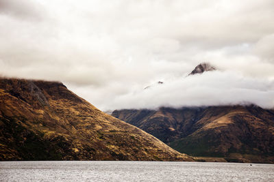 Scenic view of sea and mountains against sky