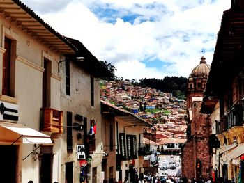 Houses by street in town against sky