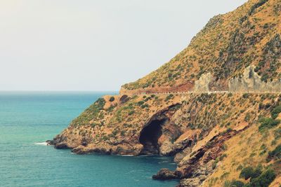 Scenic view of sea and rock formation against clear sky