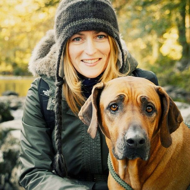 portrait, looking at camera, person, young adult, front view, smiling, lifestyles, casual clothing, happiness, leisure activity, animal themes, young men, one animal, focus on foreground, mammal, dog, domestic animals, togetherness