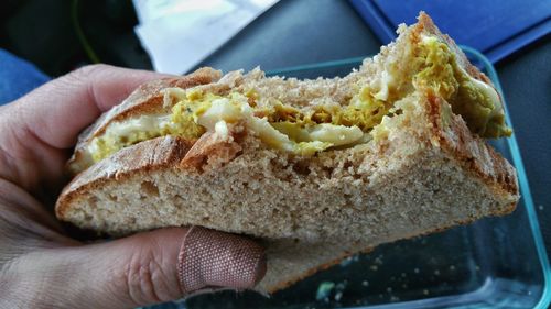 Cropped hand of person holding eaten sandwich