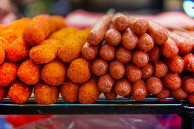 Close-up of fried hot dogs and nuggets for sale at market stall