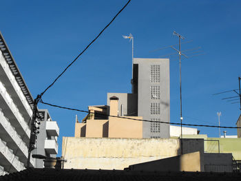 Low angle view of buildings against clear blue sky