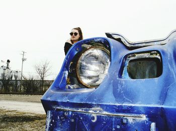 Close-up of man wearing sunglasses against blue sky