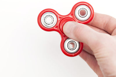 Cropped hand holding stethoscope against white background