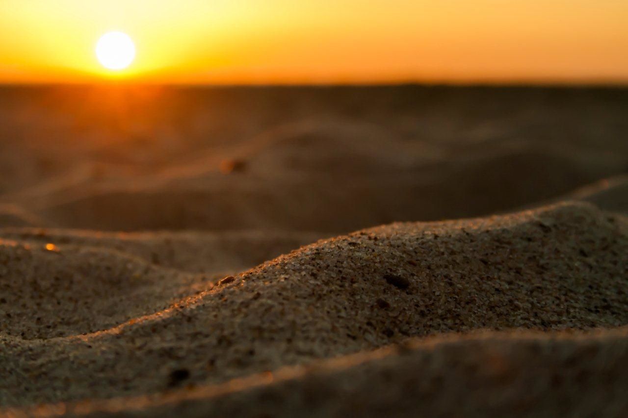 sunset, sun, scenics, tranquil scene, tranquility, sea, beauty in nature, beach, nature, orange color, sunlight, idyllic, sky, horizon over water, sand, selective focus, surface level, shore, lens flare, clear sky