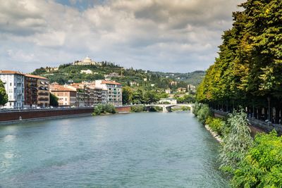 River amidst buildings in city against sky