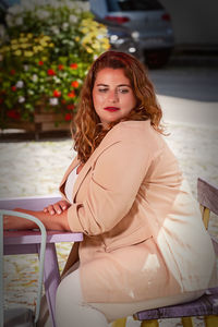 Portrait of young woman sitting outdoors