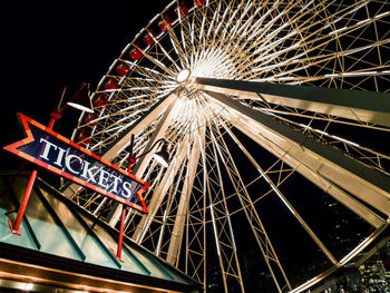 Low angle view of illuminated ferris wheel against sky at night