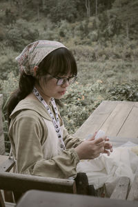 Side view of woman sitting on field