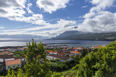 High angle view of townscape by sea against sky