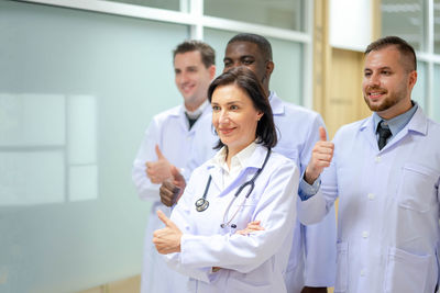 Portrait of smiling female doctor with hands in hospital