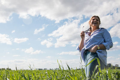 Woman standing on field against sky