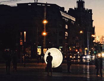 Rear view of man and woman standing in illuminated city