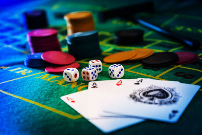 Close-up of cards with gambling chips and dices on table in casino