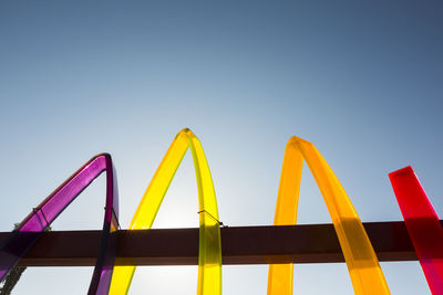 Low angle view of acrylic monument against clear blue sky