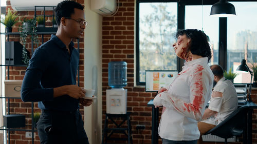 Businesswoman in zombie character in front of colleague at office