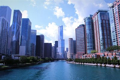 Buildings in city against cloudy sky