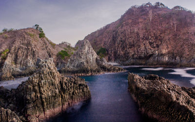 Scenic view of river amidst mountains against sky