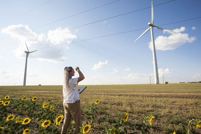 Full length of woman standing on field against sky