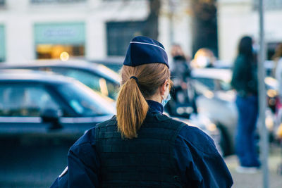 Rear view of man standing on street in city