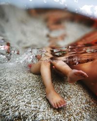 Low section of girl sitting on sea