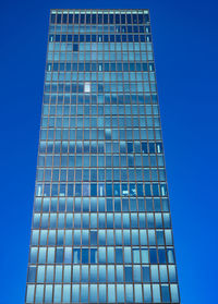 Low angle view of modern building against blue sky