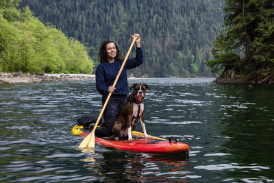 Portrait of woman with dog in lake