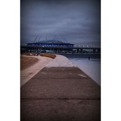 Bridge over sea against cloudy sky