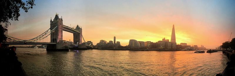 View of suspension bridge in city at sunset