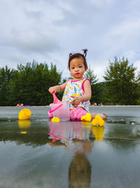 Cute girl in swimming pool against sky