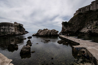 Rocks by sea against sky