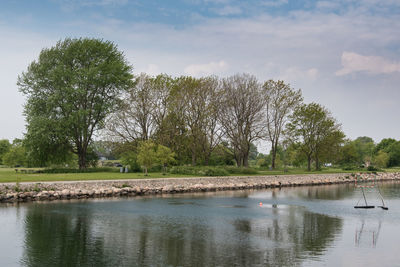 Scenic view of lake by trees against sky