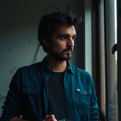 Portrait of young man looking away at home