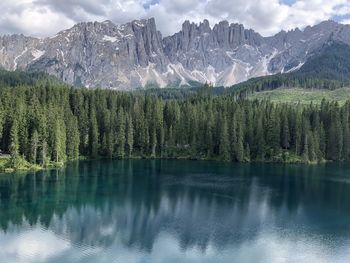 Scenic view of lake by mountains against sky