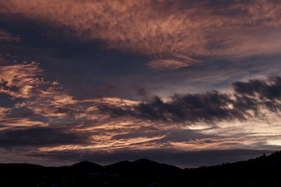 Scenic view of dramatic sky over silhouette landscape