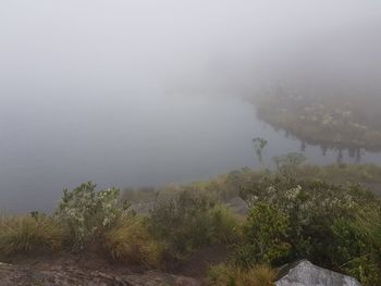 Scenic view of lake against sky during foggy weather