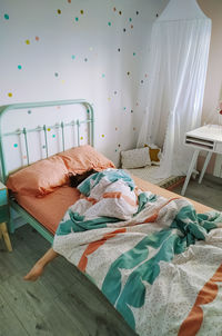 High angle view of girl sleeping on bed at home