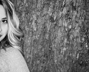 Close-up portrait of woman in tree trunk