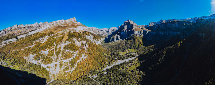 Scenic view of snowcapped mountains against clear blue sky