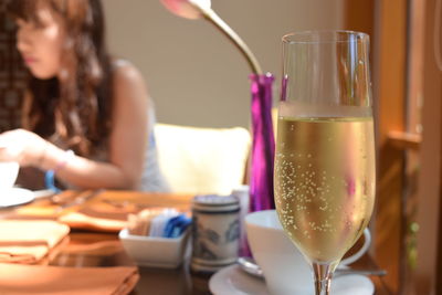 Close-up of woman holding wine glass on table