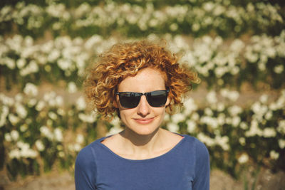 Portrait of young woman wearing sunglasses against blurred background