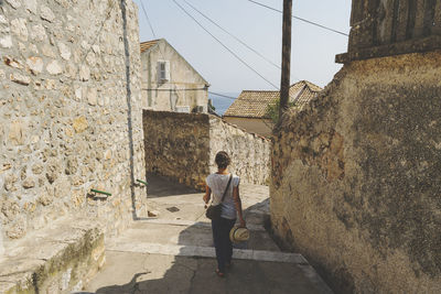 Rear view of woman walking on footpath