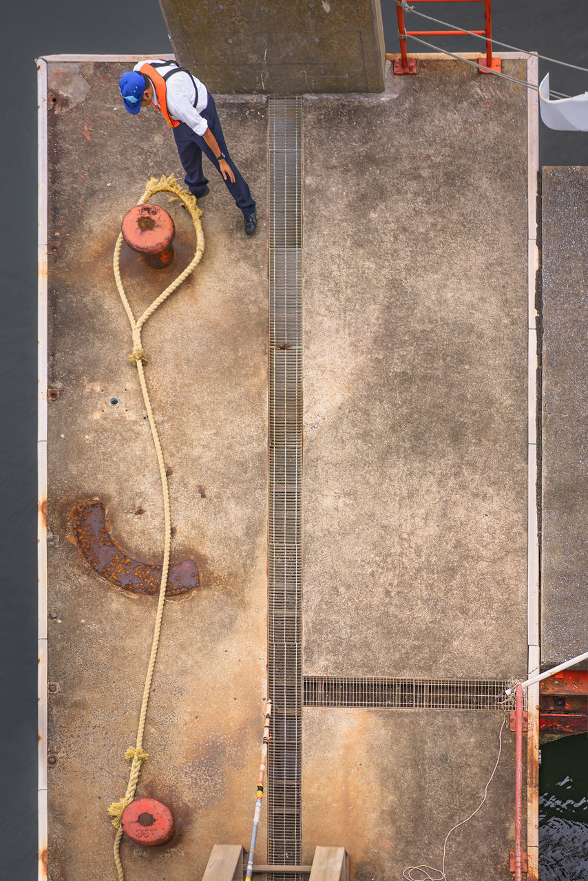 HIGH ANGLE VIEW OF MAN PLAYING SOCCER