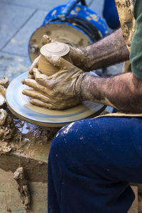 Midsection of man preparing pottery