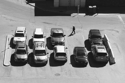 High angle view of man walking by cars parked on road