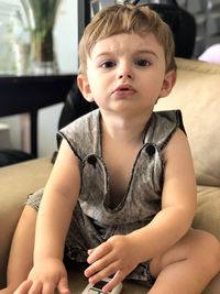 Portrait of cute boy sitting at home
